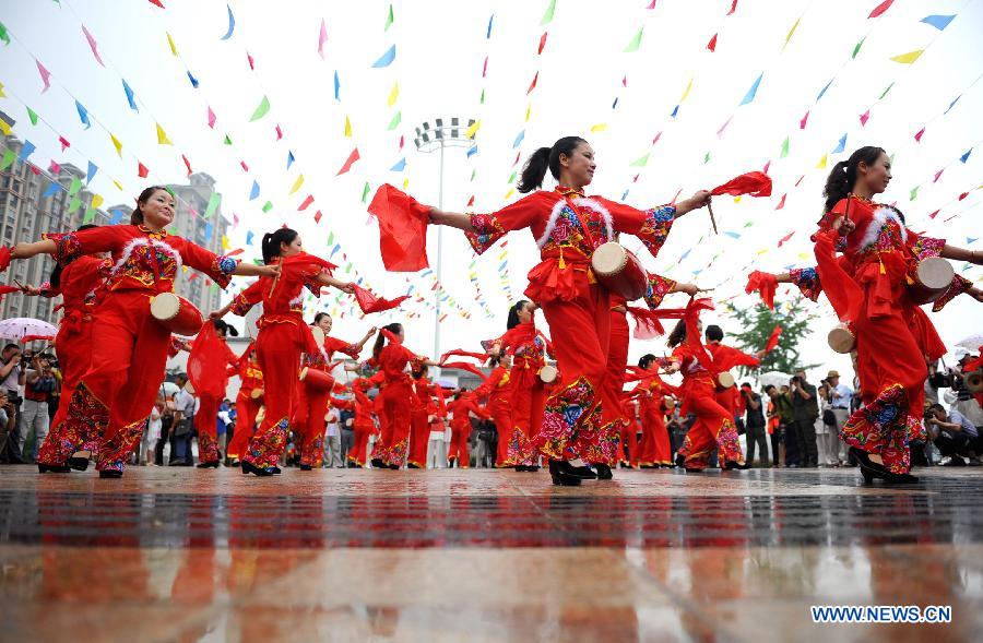 Residents play the waist drums on a street in Qianjiang City, central China's Hubei Province, June 14, 2015. 