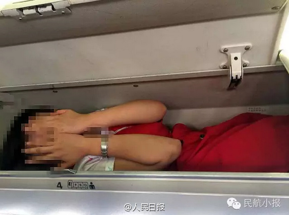 Air stewardesses packed into overhead bin