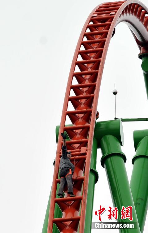 Man successfully climbs up 77-meter-high roller coaster