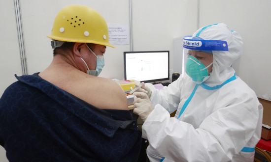 A construction worker for the Beijing Winter Olympic Games venues receives a COVID-19 vaccine on Tuesday in the capital city. Beijing has vaccinated more than 5 million residents and 2.64 million have received two doses. Photo: cnsphoto