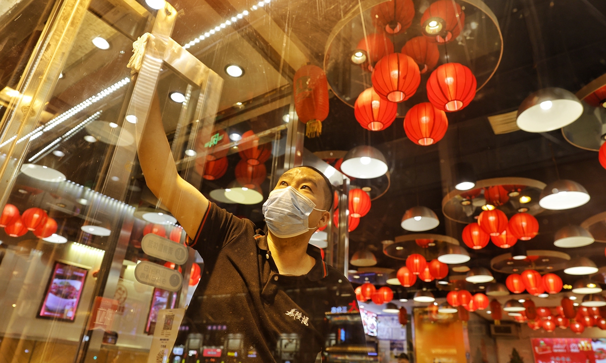 A restaurant staff member cleans a window on June 5, 2022 to prepare for the first group of dine-in customers after a hiatus of more than a month. Beijing will resume dine-in services for restaurants from June 6 after a COVID-19 resurgence was mostly curbed. Photo: Li Hao/GT
