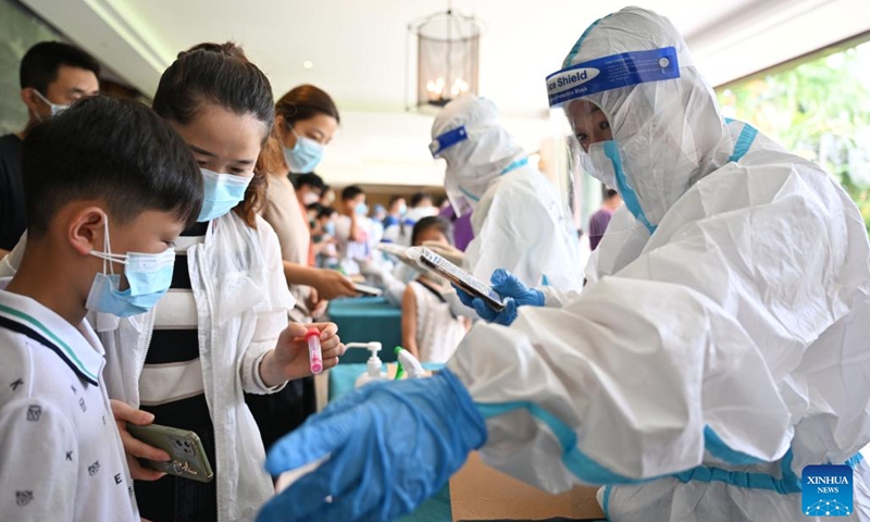Zhang Wei (1st R), a tourist-turned volunteer from Jincheng in north China's Shanxi Province, registers nucleic acid test information at a hotel in Sanya, south China's Hainan Province, Aug. 9, 2022. Amid the latest resurgence of COVID-19 in Sanya, some tourists have joined local volunteers in combating the epidemic.(Photo: Xinhua)